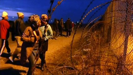 Girl passes barbed wire among migrants heading for Britain