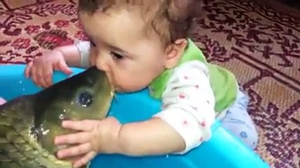 Cette mère encourage son bébé à faire des bises à un poisson qui peut mordre.
