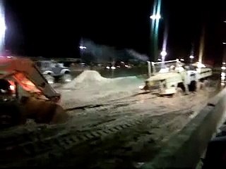 Tractor pulls out stuck duece and a half military truck in mud.