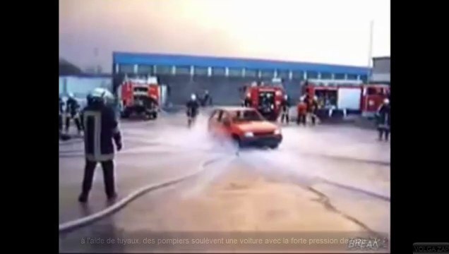 à l'aide de tuyaux, des pompiers soulèvent une voiture avec la forte pression de l'eau
