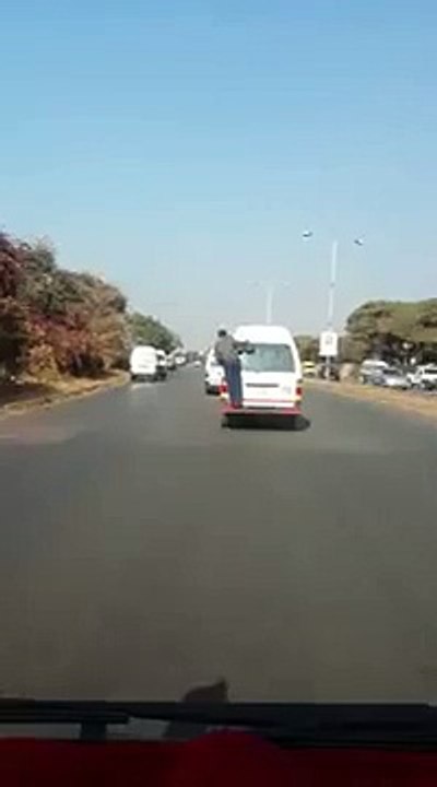 Police falls at the back of a kombie in Zimbabwe