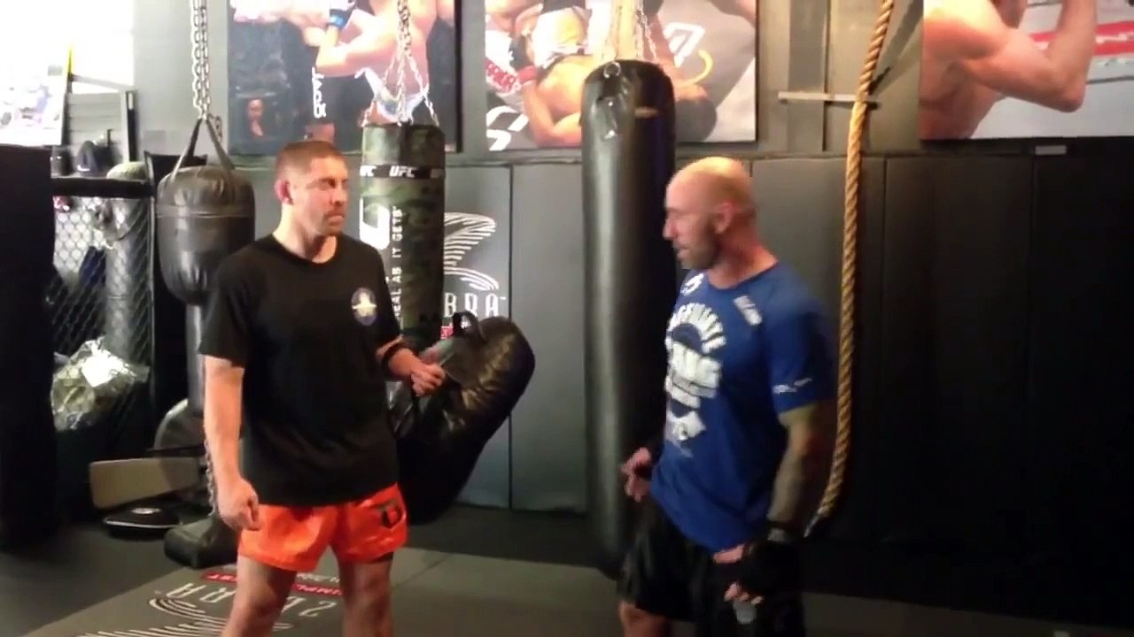 Joe Rogan kicks really hard while Duane "Bang" Ludwig holds pads
