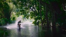 Une moto qui roule sur l'eau et fait du surf