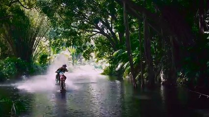 Il roule sur l'eau et surfe sur la vague en motocross