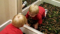 funny baby talking to himself in the mirror