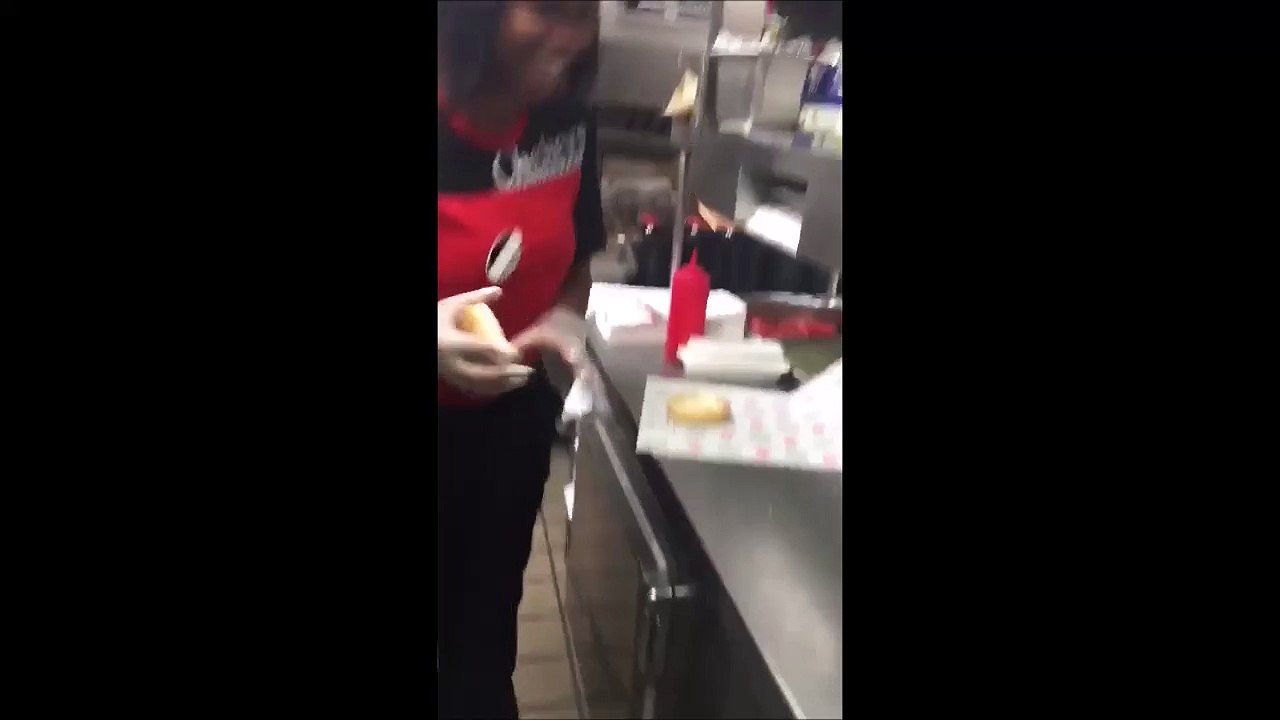 Une employée de Fast Food frotte le pain burger au sol et l'utilise pour préparer un hamburger