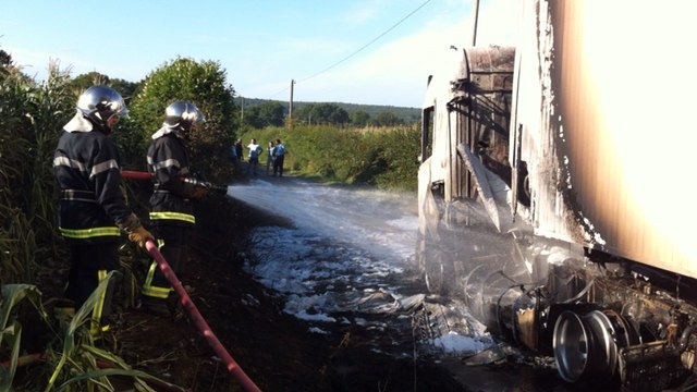 Un camion s'embrase sur une route de campagne
