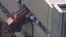 Sanitation truck dangles from building in New York