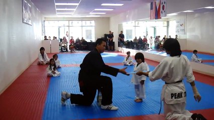 Un petit garçon tente désespérément de casser une planche au Taekwondo