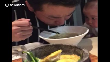 Cute baby stares intensely at dad while he eats