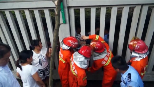 Firemen free girl from fence railings