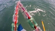 Reciclando garrafas de 2 litros PET em um belo caiaque, navengando na Baia do Flamengo, Ubatuba, Brasil