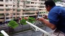 Cet homme peche et attrape un poisson depuis son balcon