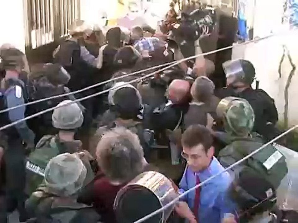 جندي اسرائيلي ينطح امرأه فلسطينيه