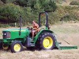 John Deere 5415 cutting grass with a topping mower