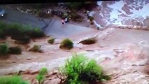 Arizona Monsoon. Two people walking too close to raging flood water!!  Wickenburg 2015