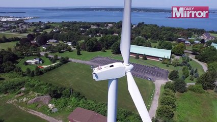 Un drone surprend un homme en pleine séance de bronzage au sommet d'une éolienne.