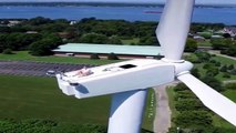 Drone pilot spots man sunbathing on top of wind turbine