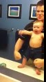 Baby adorably flexes muscles with dad