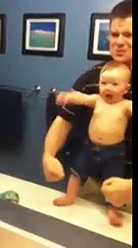 Baby adorably flexes muscles with dad