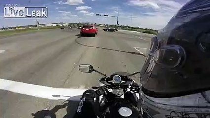 Female driver gets stuck in intersection...BACKS UP AND NEARLY KILLS BIKER