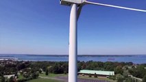 Drone captures man sunbathing on top of wind turbine