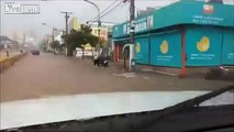 Biker in a flood is almost swallowed by manhole