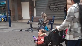 Pigeons crawling over elderly person at lunch time.