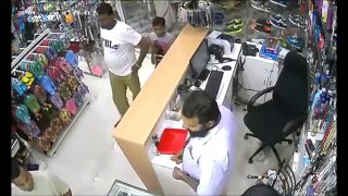 Kid steal phone from cash register while dad distracts the shop owner