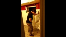 Un homme ivre essaie de se rhabiller aux toilettes