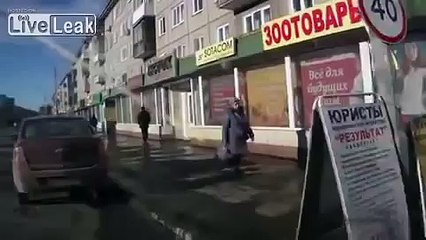 RAW Pedestrian crossing road throws beer bottle at approaching car