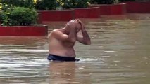 Crazy man swimming, diving and at the end falling in flooded street