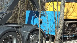 New Holland excavator which had windows shattered gets loaded on a Scania truck April 2015