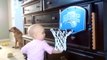 Cute baby slam dunks basketball in hoop