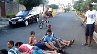 Carlos pulando 10 pessoas de bicicleta