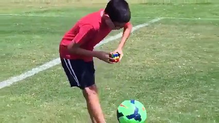 A kid doing Rubik's Cube while playing keepie uppies #Amazing