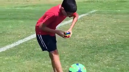 Amazing - A kid doing Rubik's Cube while playing keepie uppies