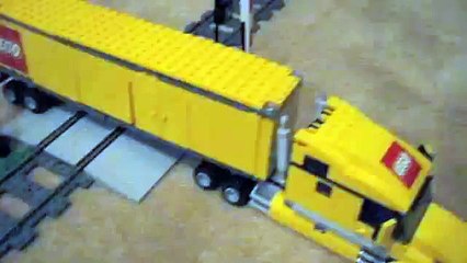 lego train plows though a semi truck