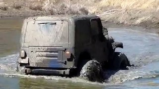 A jeep in muddy pond