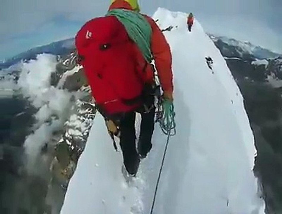 Suivez cet alpiniste sur la crête d'une montagne... Vertigineux!