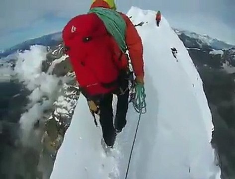 Suivez cet alpiniste sur la crête d'une montagne... Vertigineux!