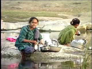 Maldhari women wash clothes by the river