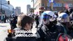 4K UHD - Riot policeman taking and breaking glass bottle away from crowd