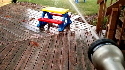 Toddler adorably entertained by water hose