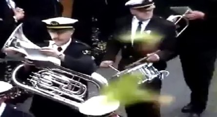 Il trolle le passage d'une fanfare depuis son balcon