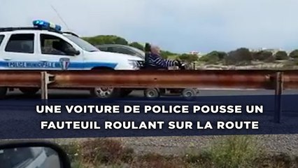 Une voiture de police pousse un fauteuil roulant sur la route