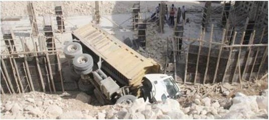 Freni boşalan kamyon inşaata devrildi