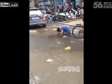 Woman washes hair in water pool on street