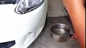 Il se sert de l'eau bouillante pour réparer la bosse sur sa voiture