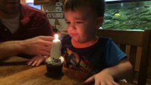 Kid has trouble blowing his birthday candle